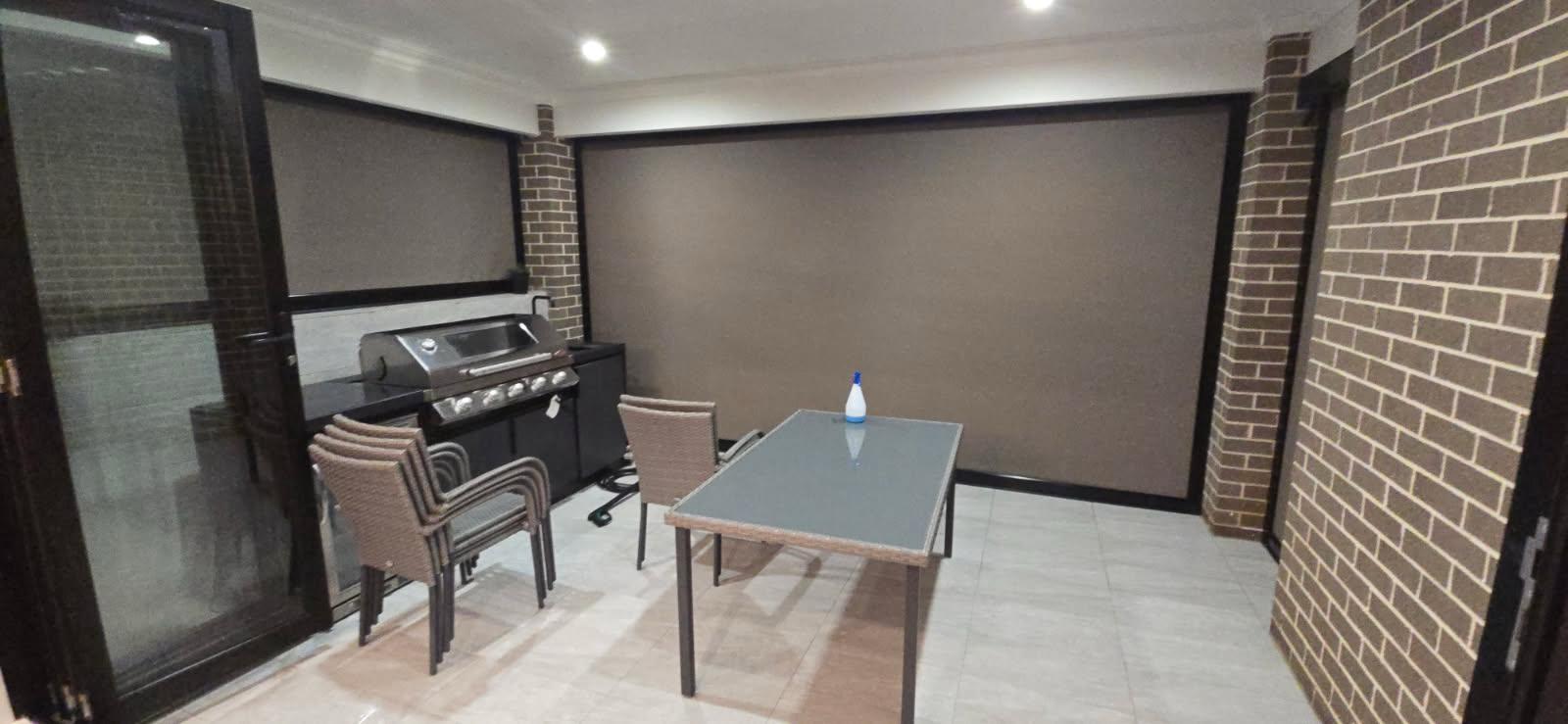 Modern custom outdoor blinds enclosing a beautiful Sydney patio for year-round entertaining